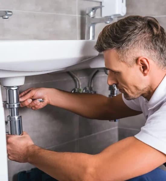 adult-plumber-fixing-sink-at-bathroom